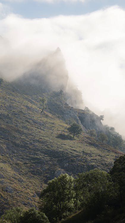 Green Mountain Slope Under White Clouds