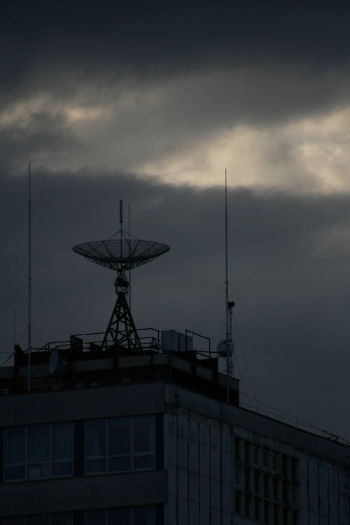 Antennas at the Rooftop of a Building under a Cloudy Sky