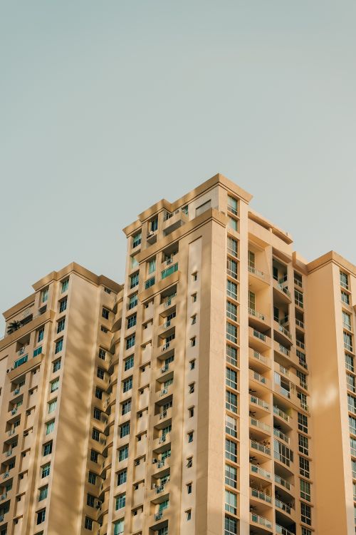 Free Sunlit tall residential building with clear sky backdrop showcasing modern architecture. Stock Photo