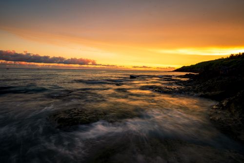 Free Experience a breathtaking sunset over the ocean with vibrant colors and serene waves. Stock Photo