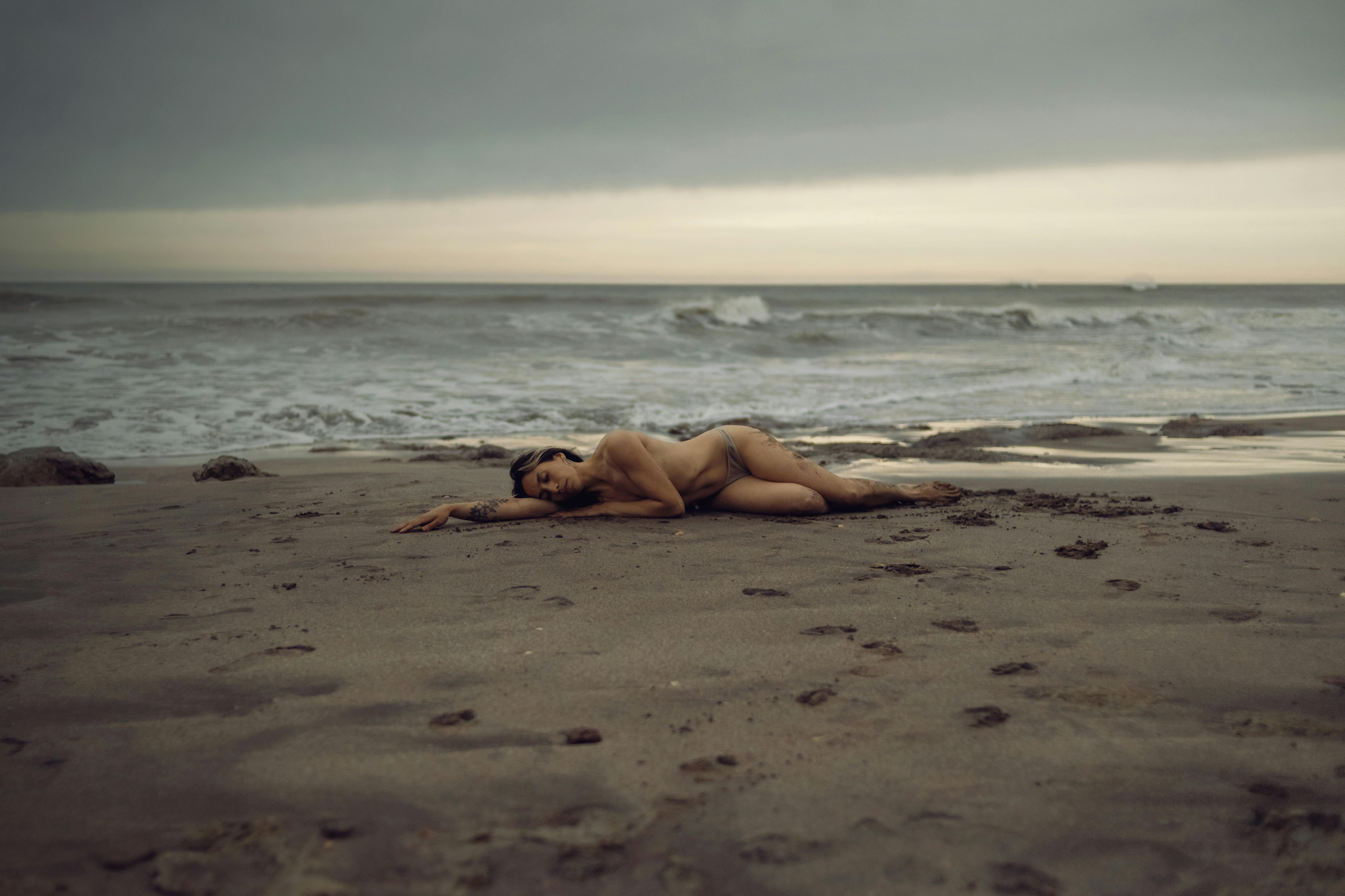 nude woman lying on a beach