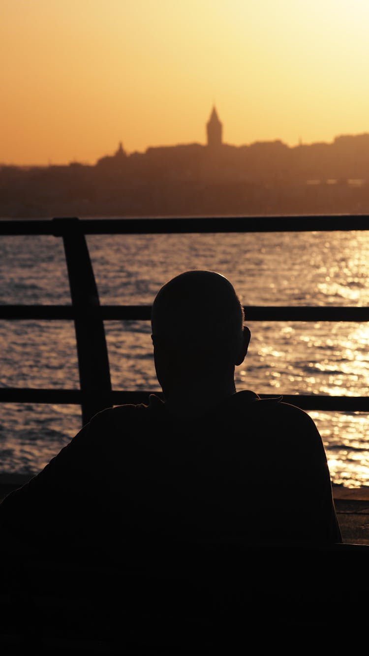 Silhouette Of A Person Near A Railing