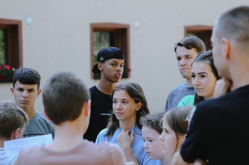 Free Teenagers gathered outdoors engaged in a lively discussion, fostering communication and learning. Stock Photo