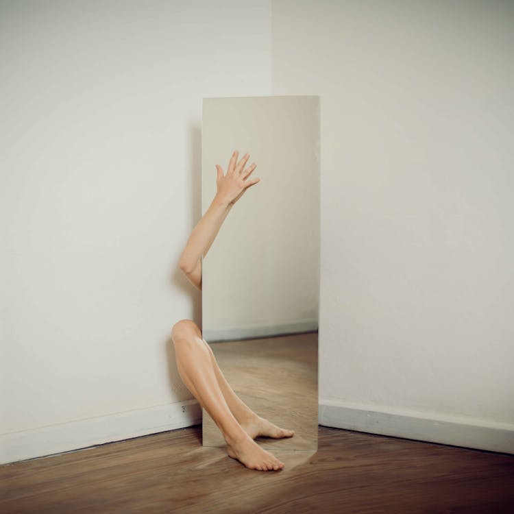 Woman Behind Mirror In Room Corner