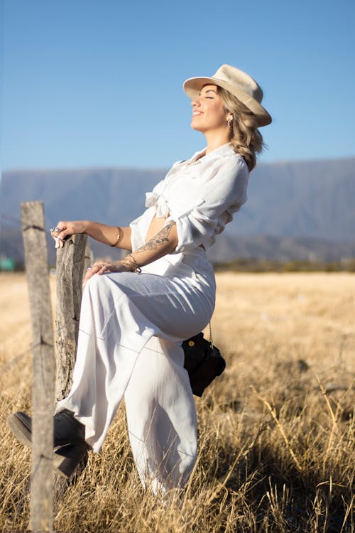 Woman in White Clothes on Wooden Fence in the Farm