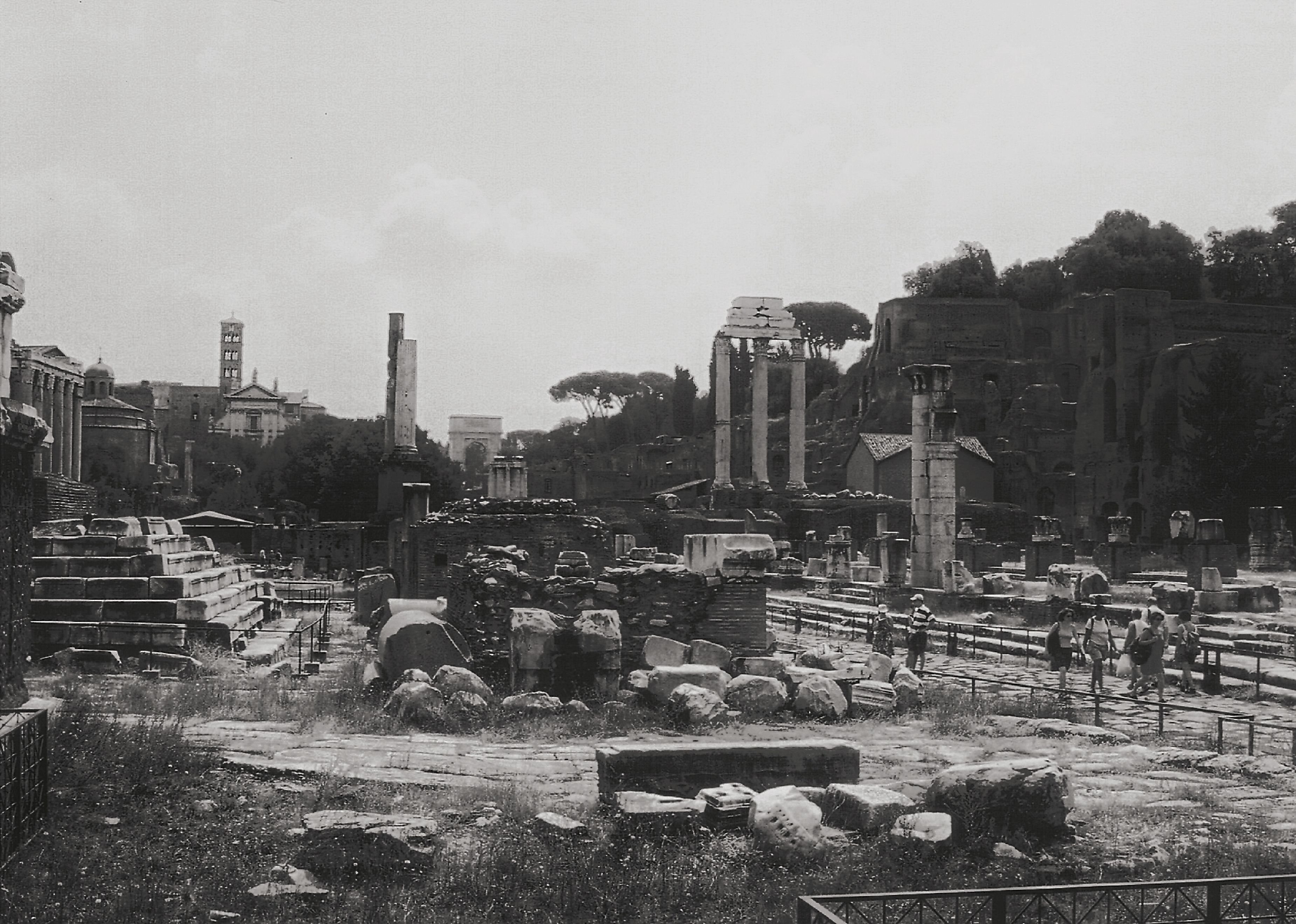 Black and white photo of ancient Roman Forum in Rome, showcasing ruins and historical architecture.