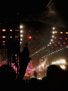 Vibrant concert scene with a cheering crowd and dynamic stage lighting in Chorzow, Poland.