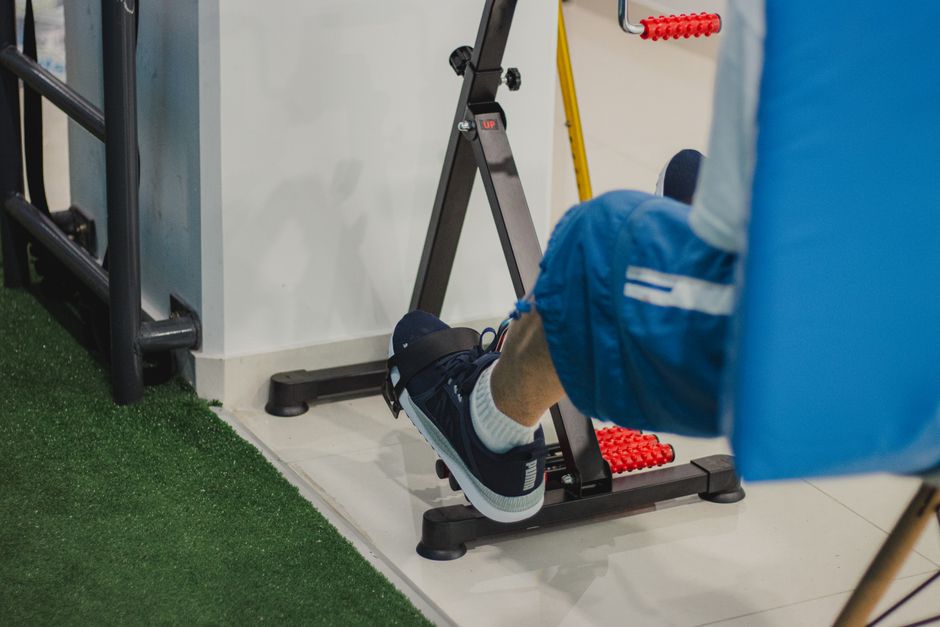 Close-up of a man working out on a stationary bike indoors, focusing on fitness and health.