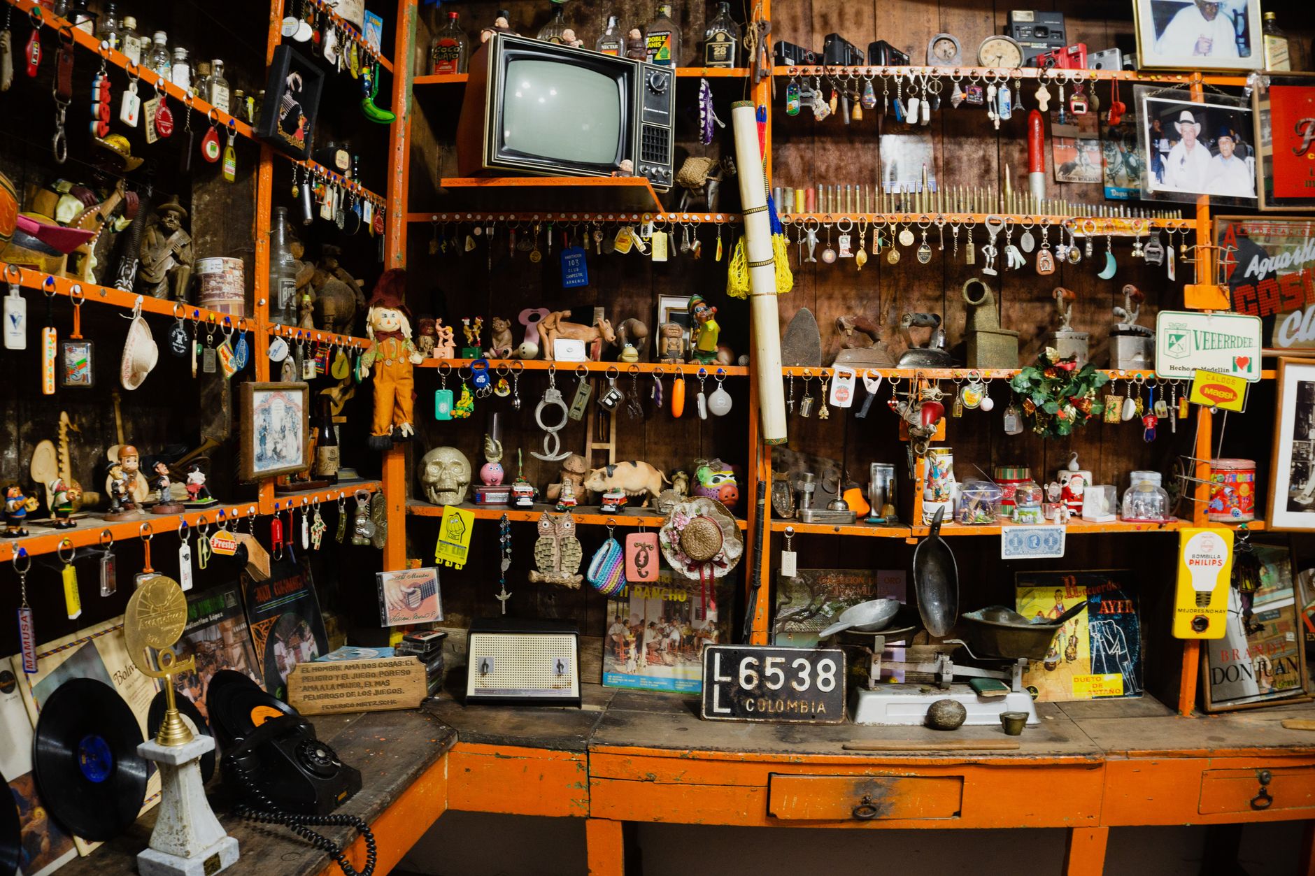 tienda de barrio colombiana con estantes de productos y un ventilador en una tarde calurosa