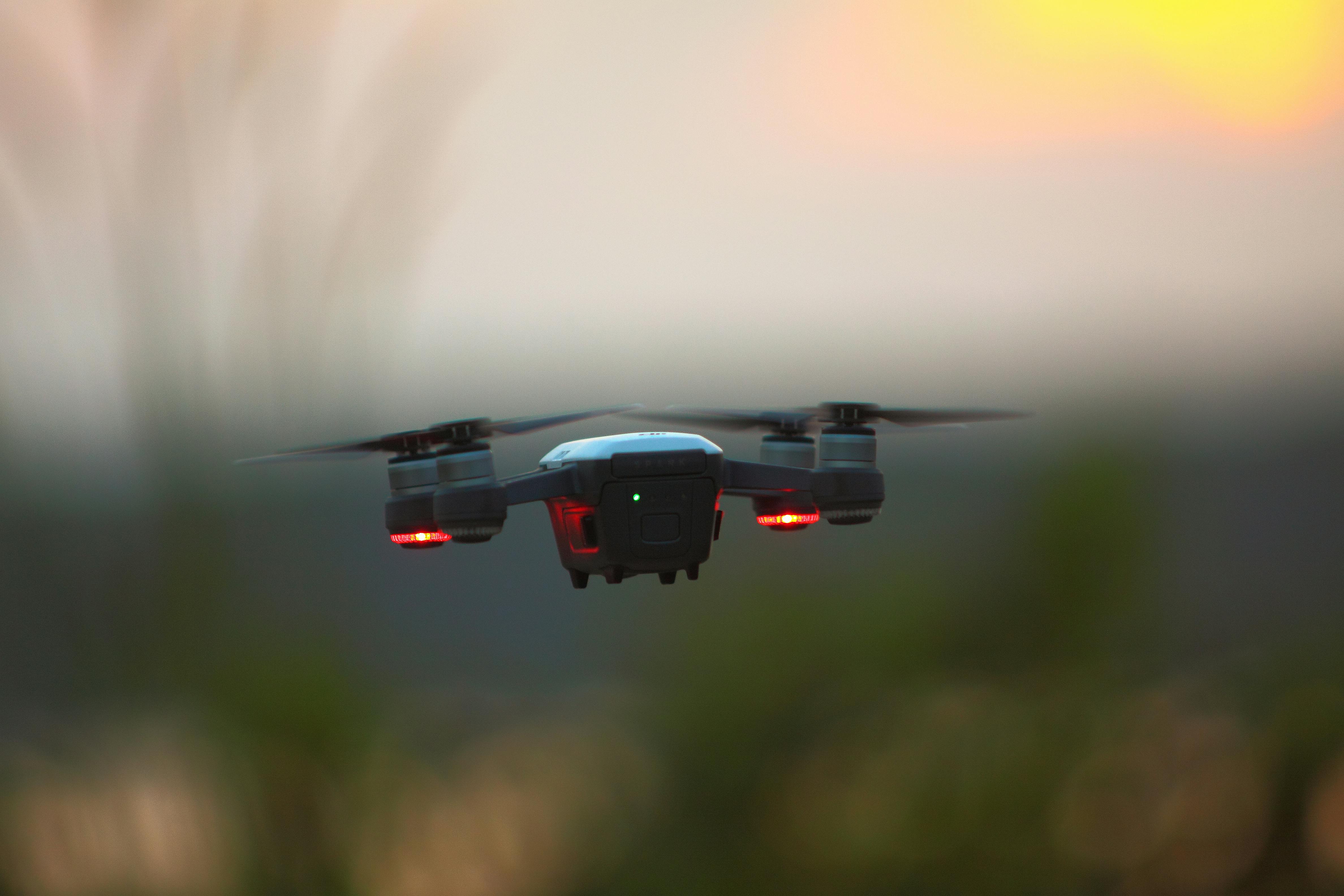 Free A drone hovering during a vibrant sunset, capturing the tranquil outdoors scene. Stock Photo