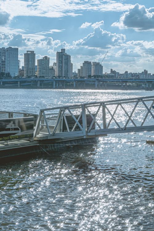 Free Explore the stunning Seoul skyline with shimmering reflections over the Han River on a sunny day. Stock Photo