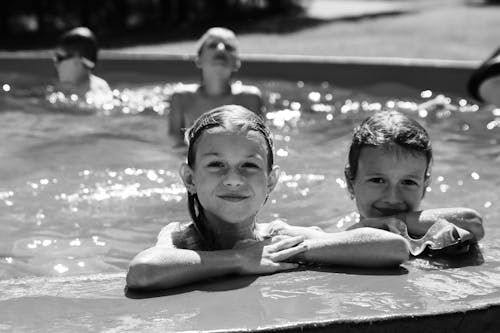 A Grayscale Photo of Two Girls in a Swimming Pool