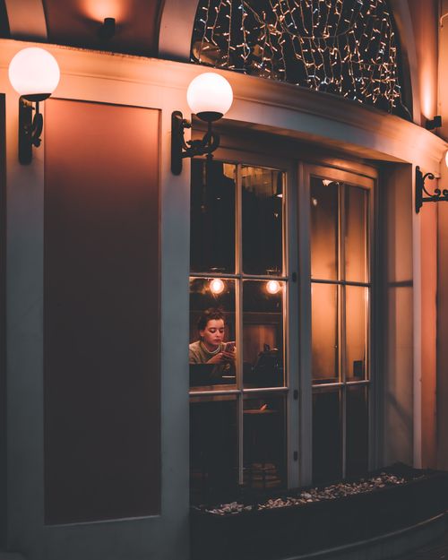 Free A warm, cozy evening atmosphere at a cafe with soft illumination and visible interior decor. Stock Photo