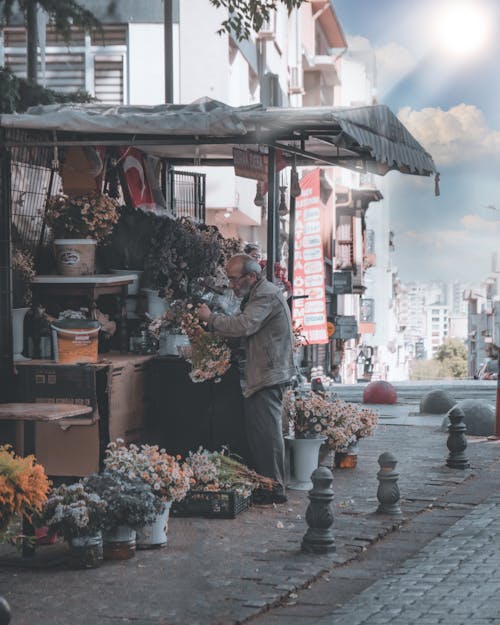 Man in Gray Jacket Selling Flowers on the Street