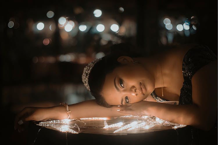 Woman Leaning Head On Illuminated Table