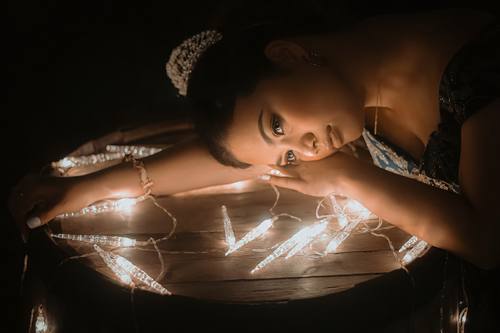 Free Artistic portrait of a woman illuminated by fairy lights, creating a moody ambiance. Stock Photo