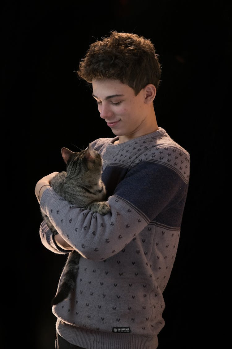 A Man In Gray Sweater Carrying A Cat 