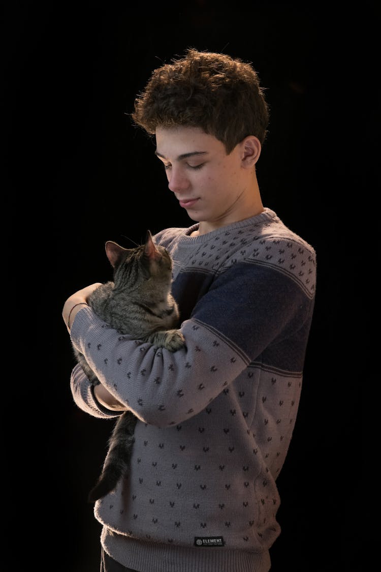 A Man In Gray Sweater Carrying A Cat