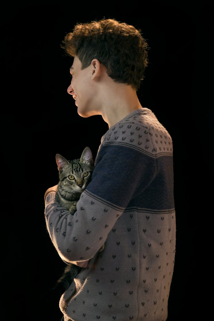 A Man In Gray Sweater Carrying A Cat