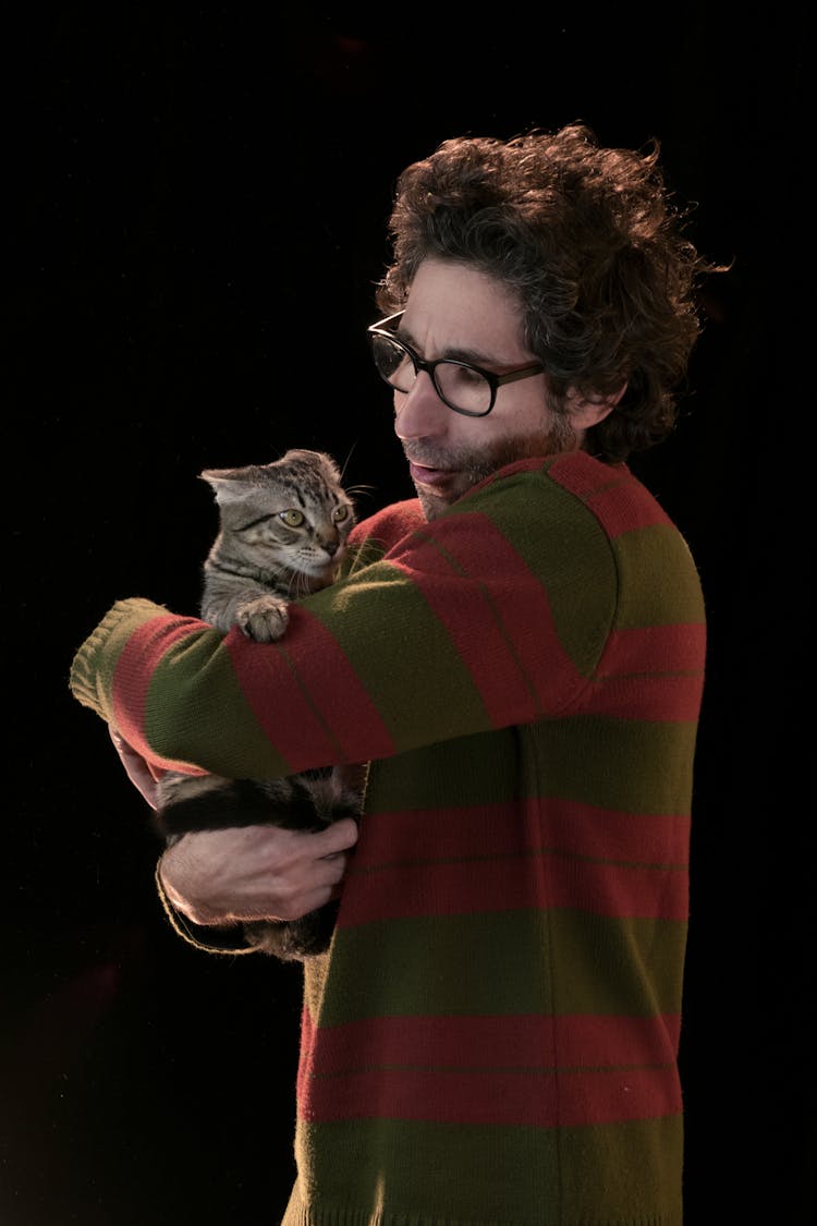 A Man Wearing Sweater Holding A Cat