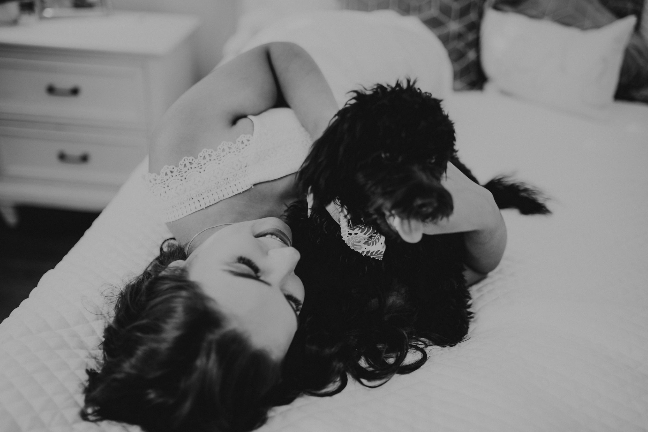 A woman embracing a poodle in a cozy room setting. Perfect for lifestyle imagery.