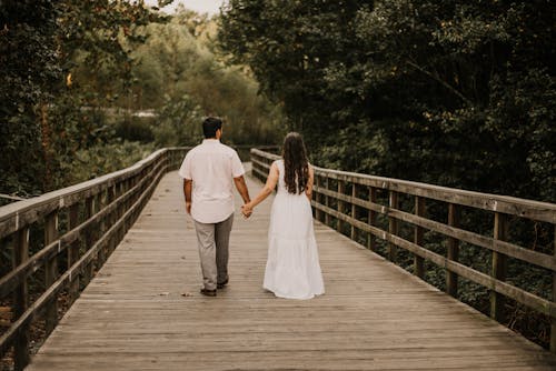 Free A Romantic Couple Walking on a Wooden Bridge Stock Photo