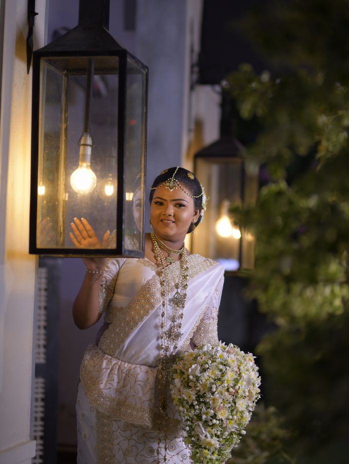 Bride at dusk by lantern light after her going-away