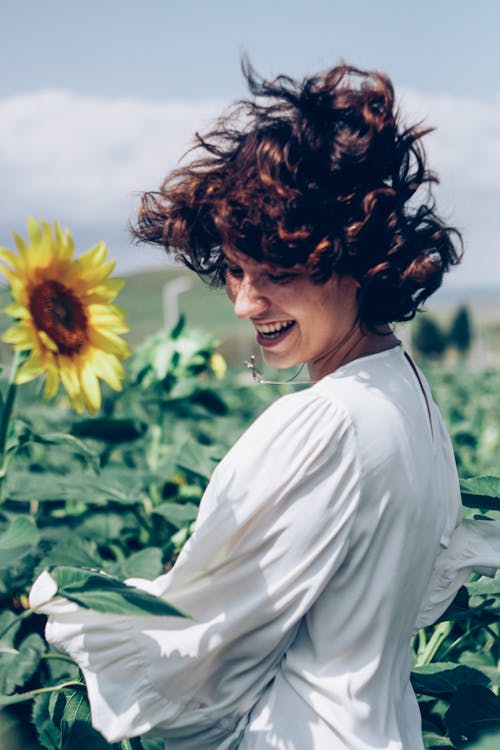 Woman Smiling at Field of Sunflowers