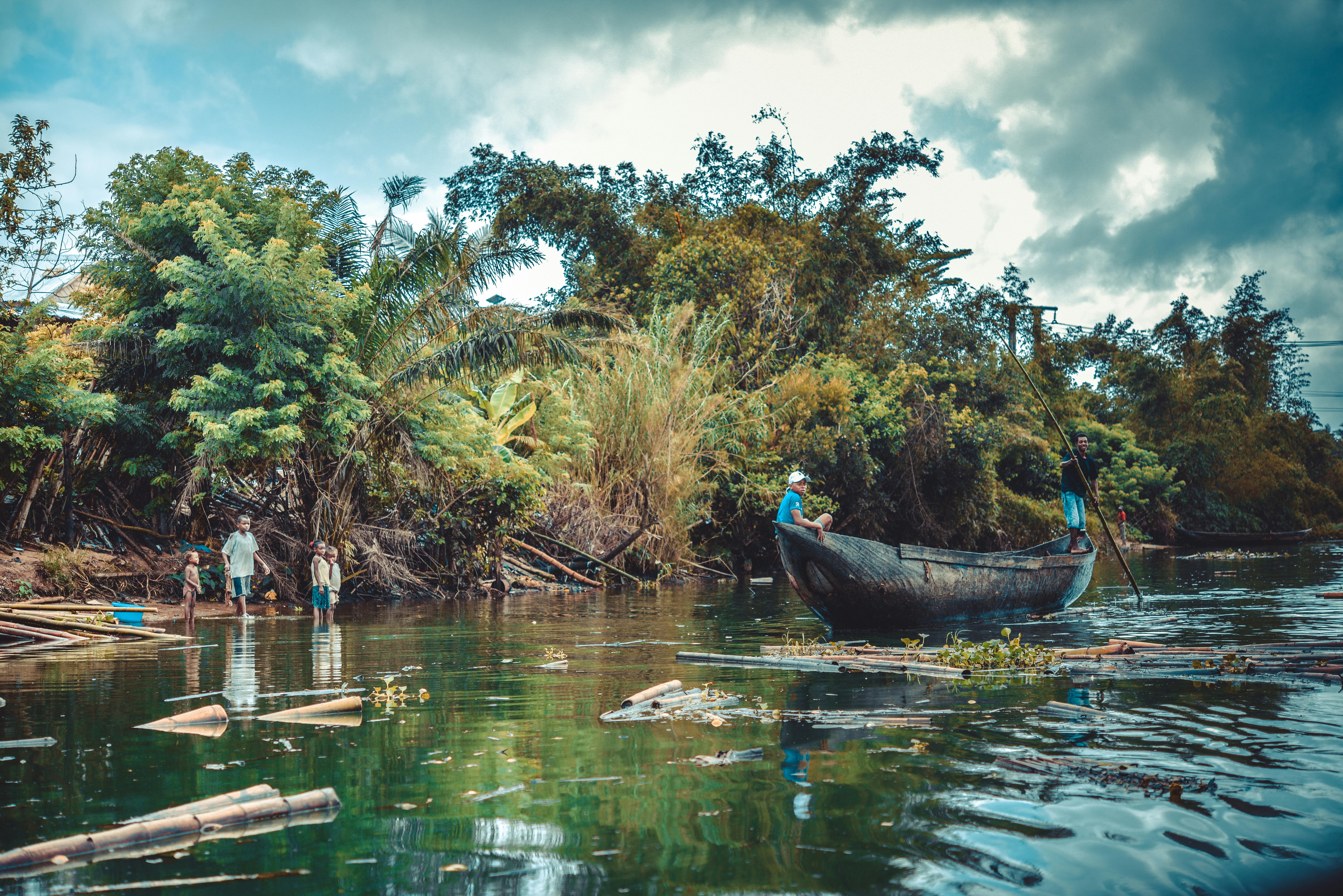 best eco-tourism experiences in the riviera maya for travel agents - Scenic view of people boating on a lush river surrounded by vibrant greenery in Madagascar.