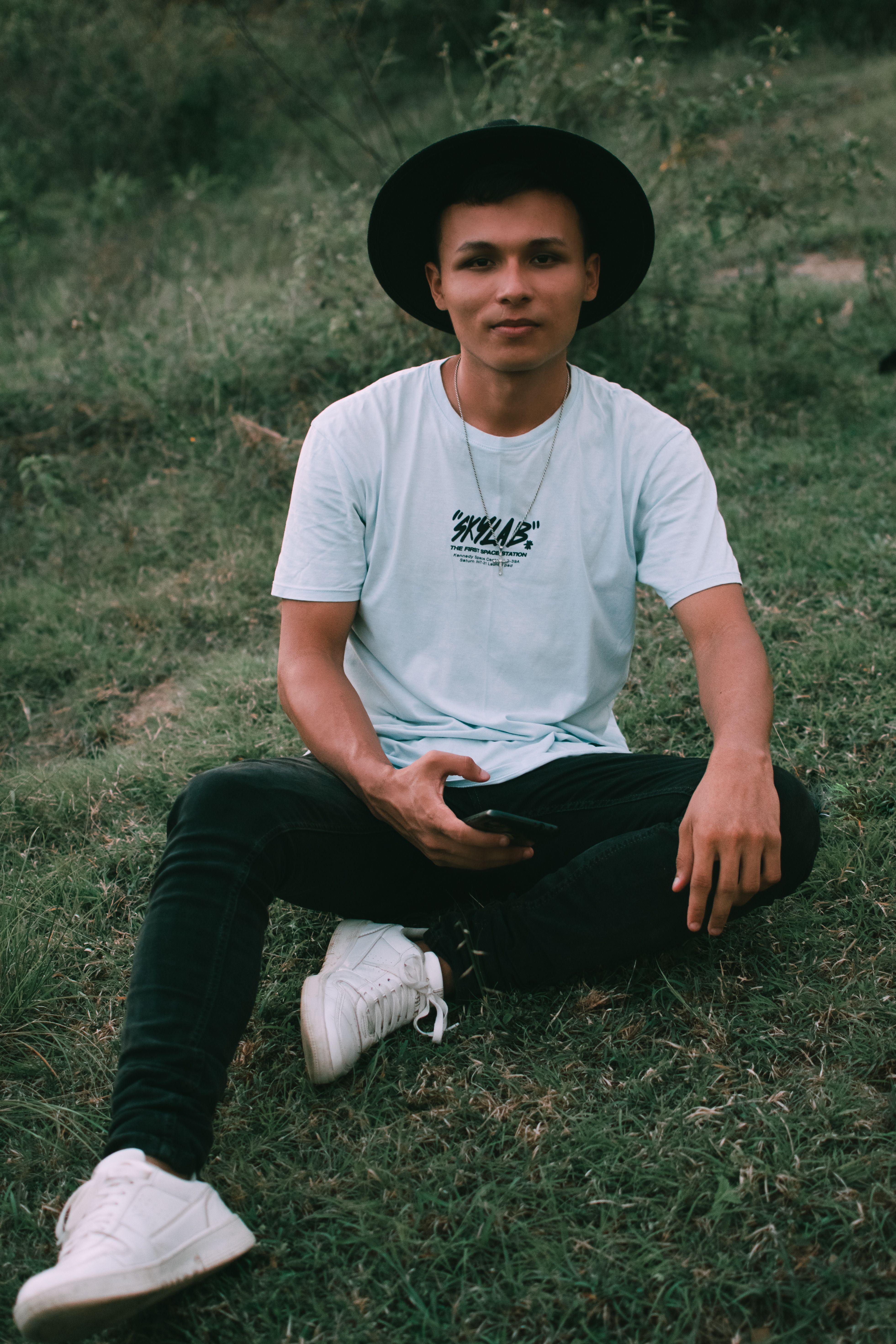 Man Wearing a White Shirt Sitting on the Grass · Free Stock Photo