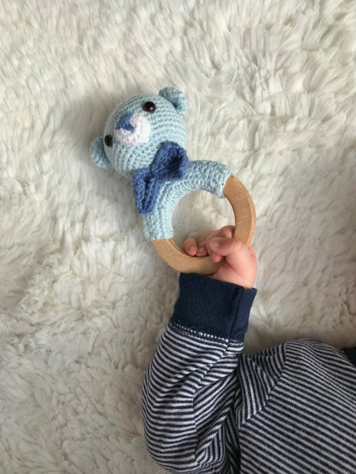 Baby Holding Blue and White Bear Plush Toy