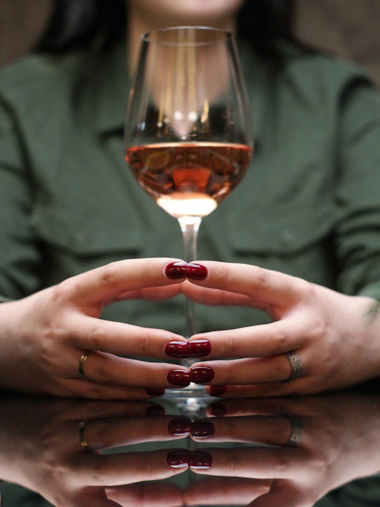 A Woman Holding A Glass Of Wine