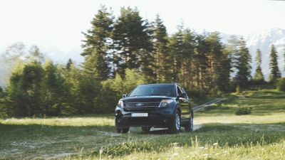 Dark estate car on a forest dirt road — photo by Beka Ichkiti on Pexels