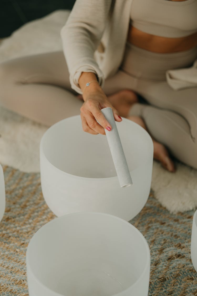 Woman With Roll In Hand And Glass Bowls On Carpet