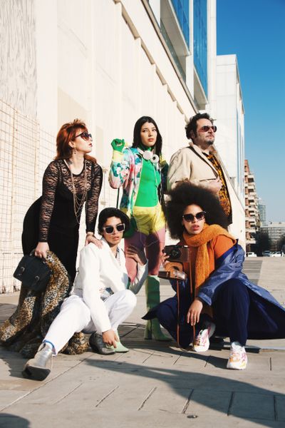 Five-piece group in eclectic outfits on a sunlit plaza — Sabrina Ibarra on Pexels