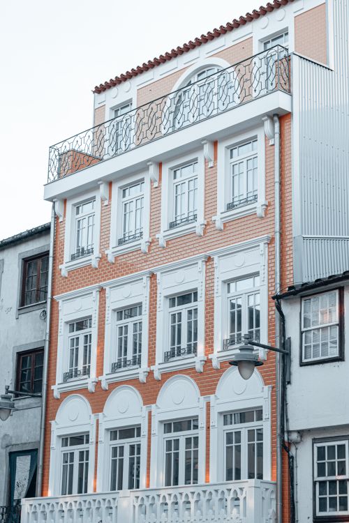 Free Elegant multi-story building with classic brick and white facade, showcasing architectural details. Stock Photo