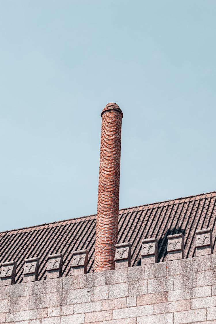 Pipe On Building Roof On Blue Sky Background