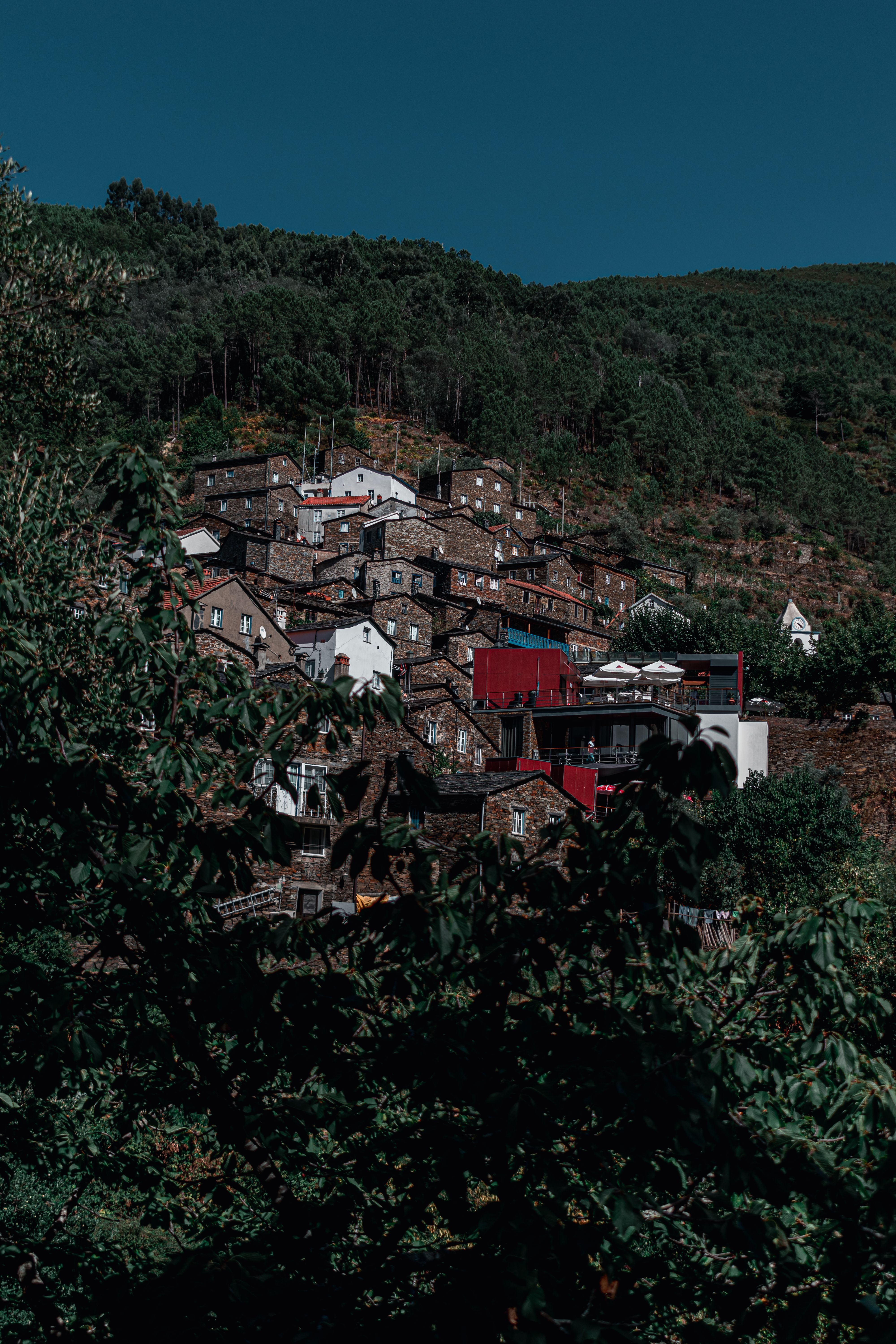 Picturesque hilltop village nestled in lush greenery under a clear blue sky.