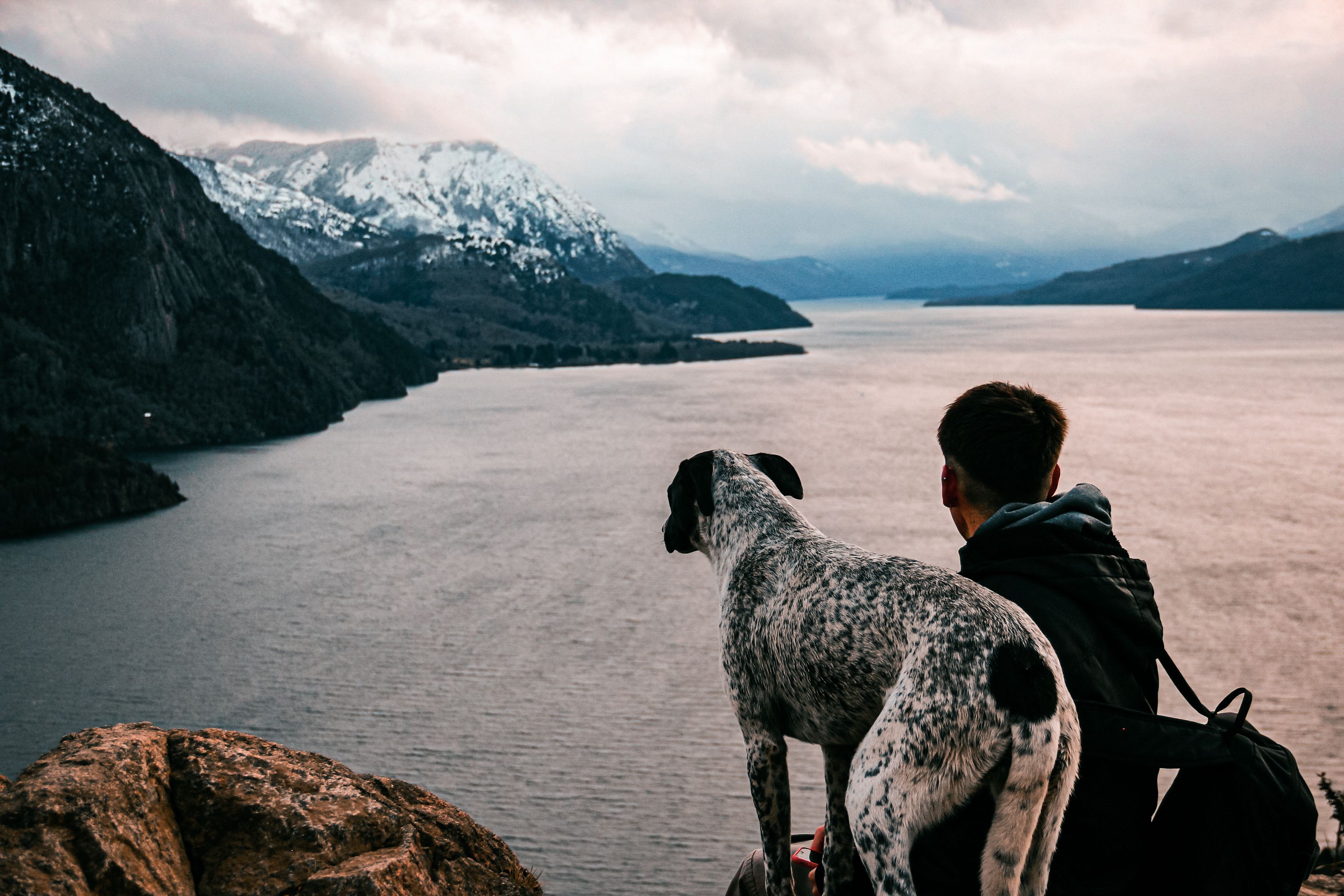 A man and his dog enjoy the majestic lakeside view in San Martín de los Andes, Argentina.