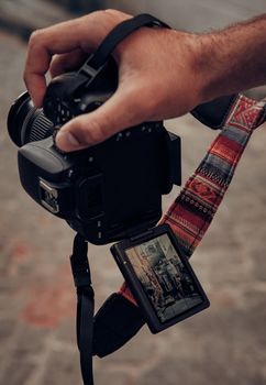 Close-up of a hand holding a camera showing a street view of İstanbul on the screen.