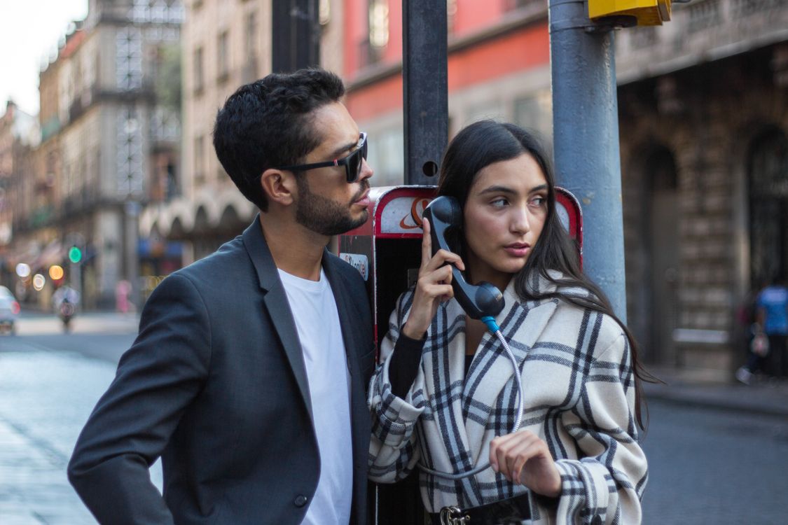 Man Standing Beside Woman Using a Payphone · Free Stock Photo