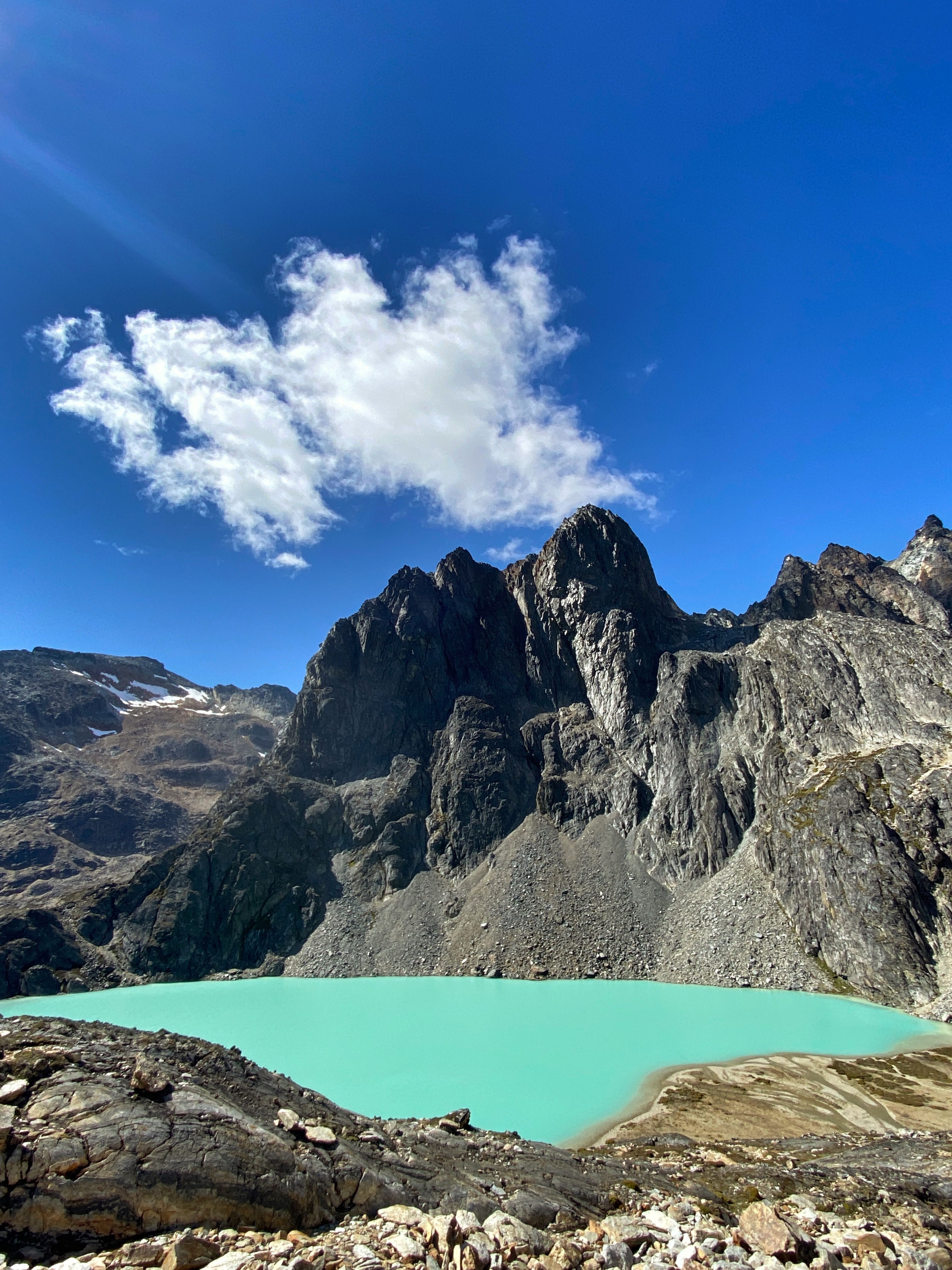 A breathtaking view of a vibrant lake amidst rocky mountains under a clear blue sky.