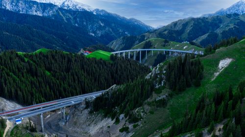 Free Breathtaking aerial shot of a bridge crossing over lush forests and majestic mountains in Kazakhstan. Stock Photo