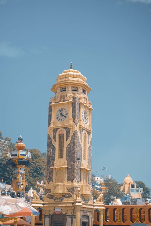 Free Beautiful clock tower against blue sky in Haridwar, India, capturing urban and cultural essence. Stock Photo