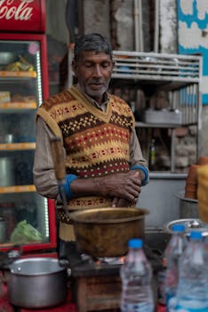 South Asian street vendor preparing food outdoors with traditional stove.