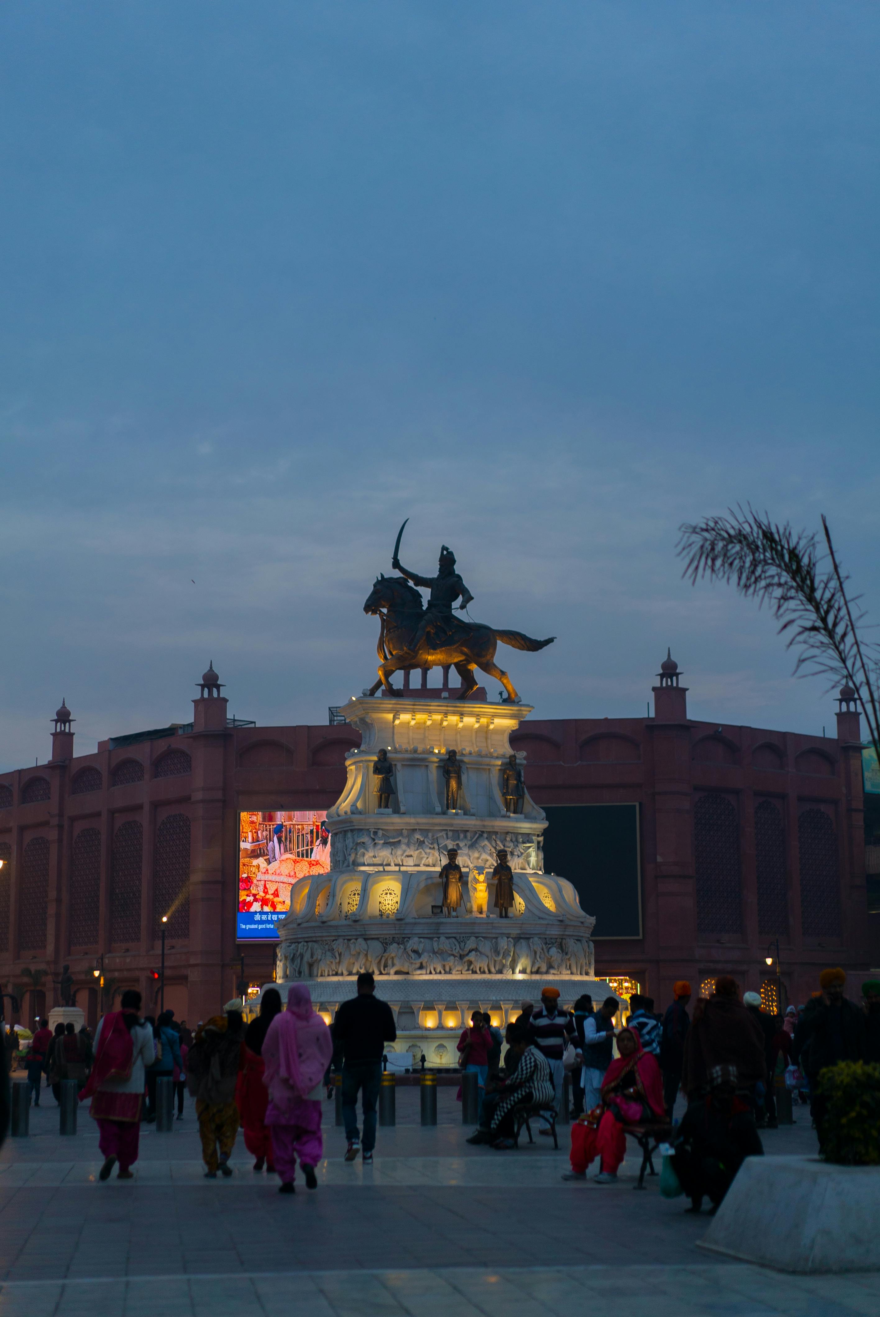 Evening view of the lit Maharaja Ranjit Singh statue, a popular tourist destination in India.
