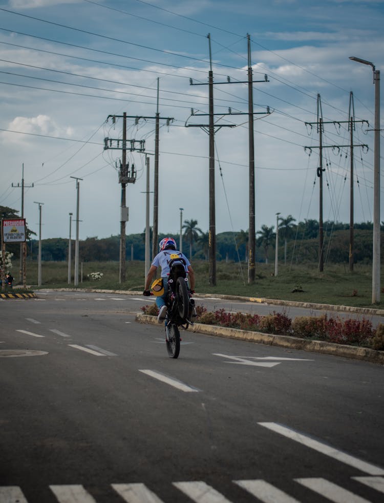 Biker Standing On The Front Wheel On A Street