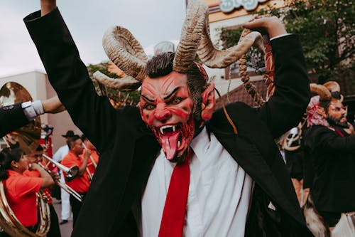 Man in Suit and Devil Mask on Parade