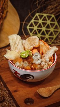 Mouthwatering bowl of Indonesian Empal Gentong with lime and crackers, perfect for food lovers. - Fotografer Sidoarjo