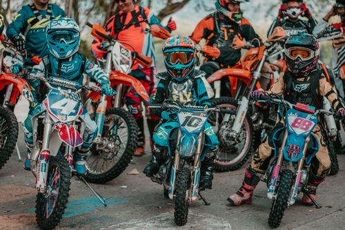Free Children compete in a thrilling motocross race on dirt bikes, showcasing youthful energy and sportsmanship. Stock Photo